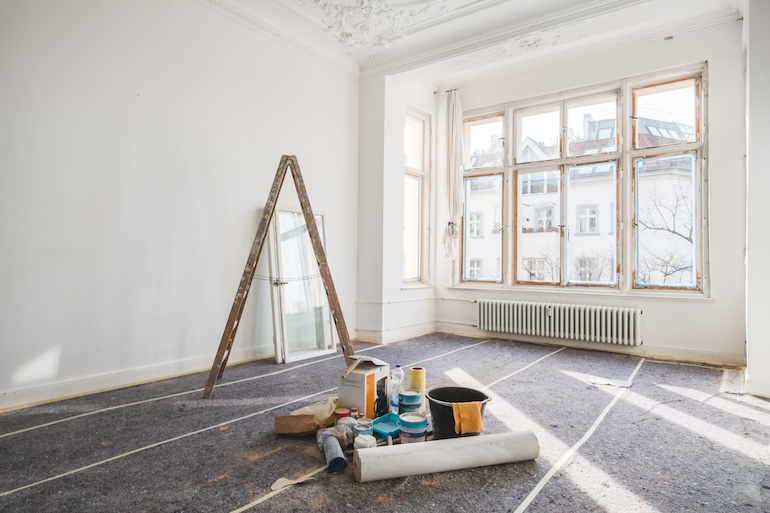 renovierungsbedürftiger Raum mit Leiter und Farbeimern