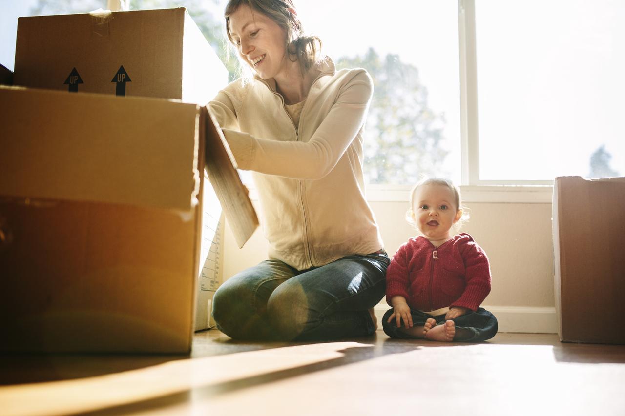 Frau mit Kind packt Umzugskartons