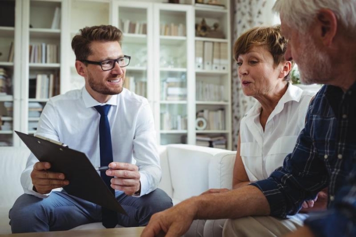 Makler berät älteres Ehepaar zum Immobilienverkauf