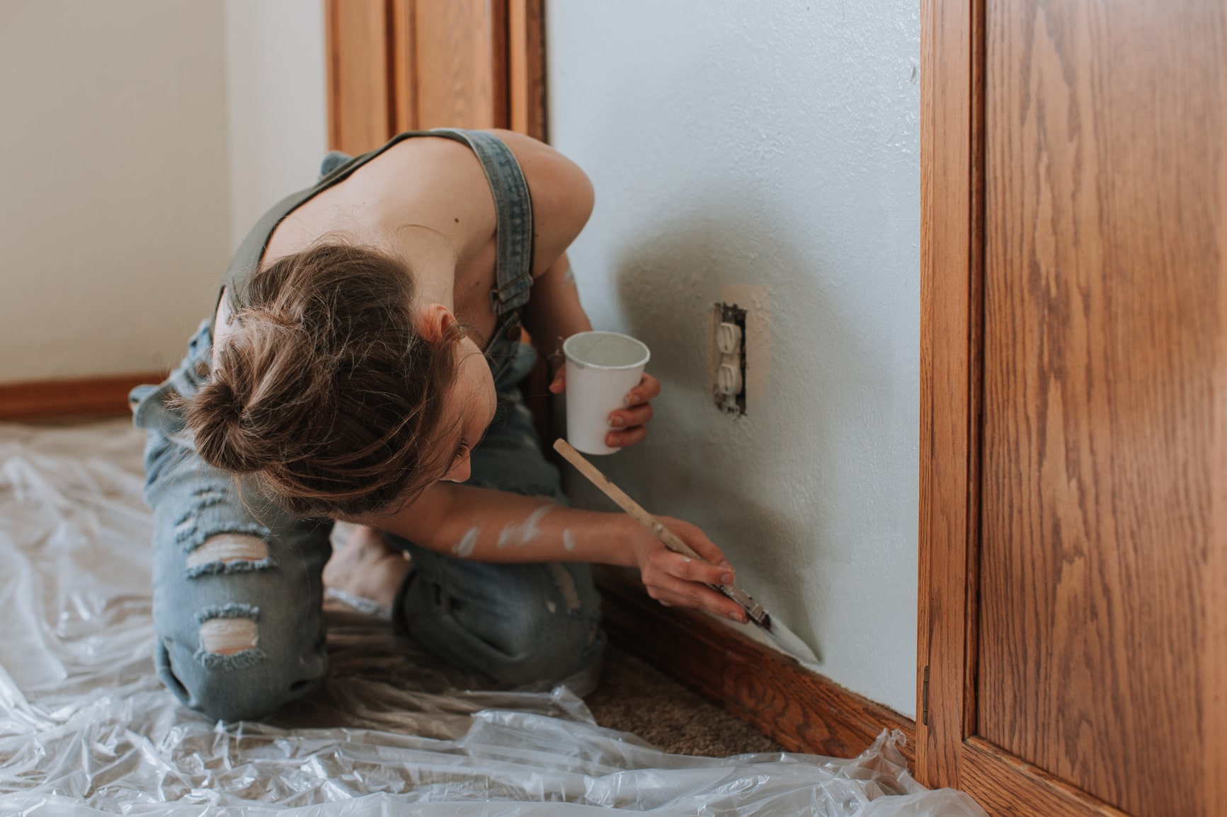 Frau malert eine Wand