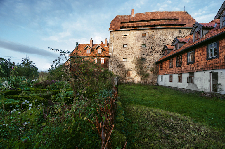 Altes Haus mit grünem Rasen und vor blauem Himmel